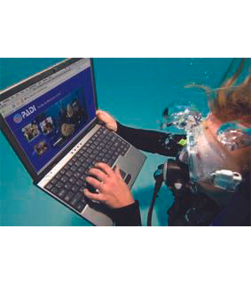 Im Bild ist ein Taucher der Unterwasser einen Laptop hält. Auf dem Laptop ist die PADI eLearning Seite aufgerufen. PADI eLearning